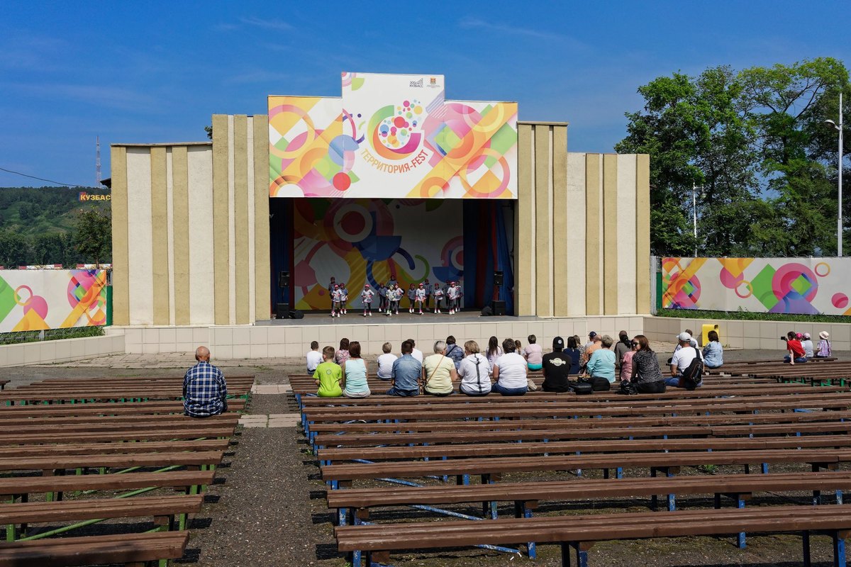 Outdoor company festival day with a covered stage, benches and activity zones