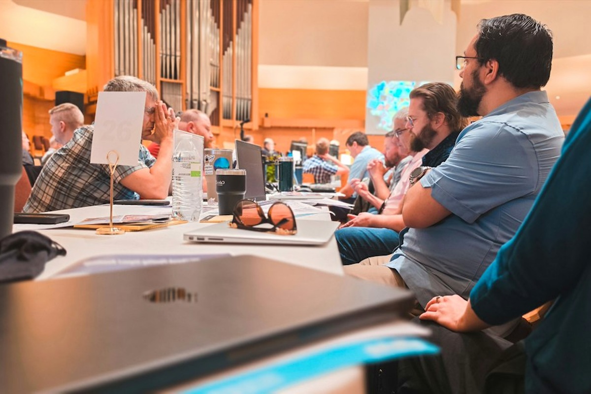 Teams of adults with answer boards at tables during a corporate quiz night