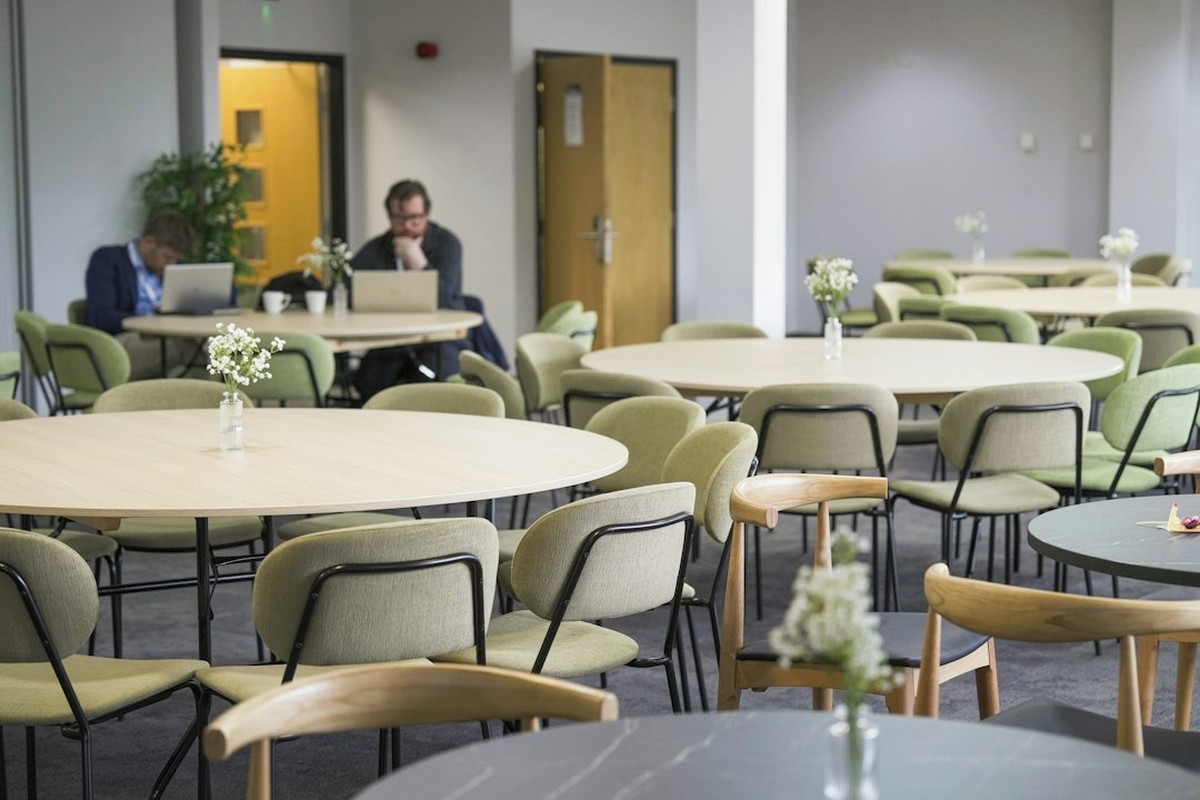 Small weekday event with a host on a microphone and teams at tables