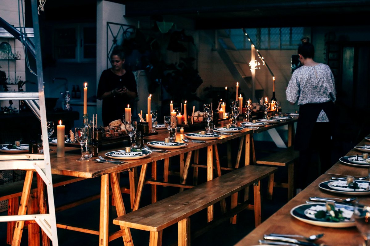Evening function room with themed tables in use and guests talking between them